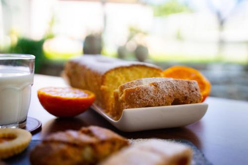 a plate of bread and oranges and a glass of milk at Il Madrigale - Agriturismo B&B in Agnone