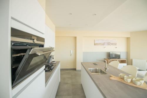 a kitchen with a sink and a stove top oven at vakantie Appartement Bel 'Vu in Middelkerke