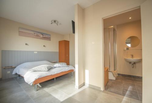 a bedroom with a bed and a sink at vakantie Appartement Bel 'Vu in Middelkerke