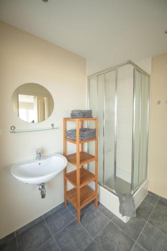 a bathroom with a sink and a glass shower at vakantie Appartement Bel 'Vu in Middelkerke