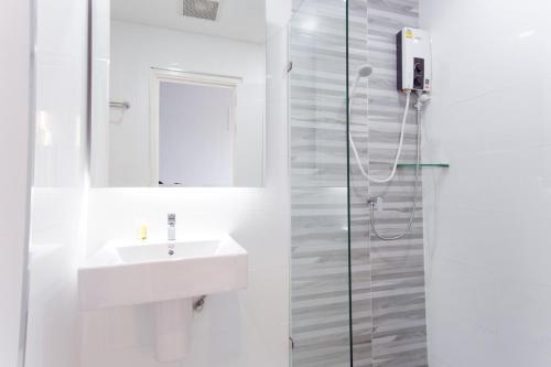 a white bathroom with a sink and a shower at ABIZZ Hotel KwanPhayao in Phayao