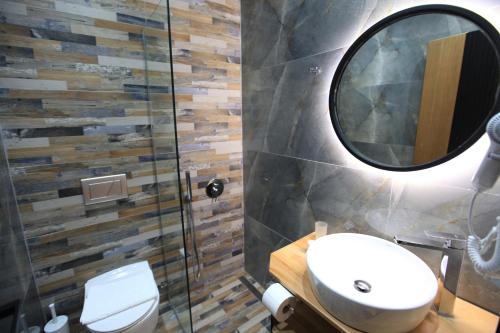 a bathroom with a toilet and a mirror at Hotel Citrus in Ksamil