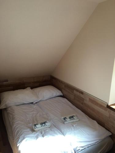 a bed in a room with two pillows on it at Domek Gloria nad Jeziorem Żywieckim in Żywiec