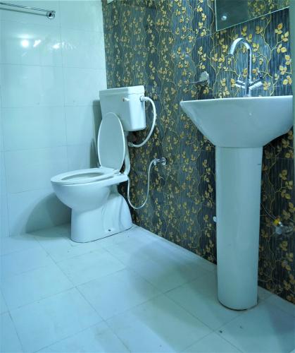 a bathroom with a toilet and a sink at Hotel Siddharth in Tanakpur