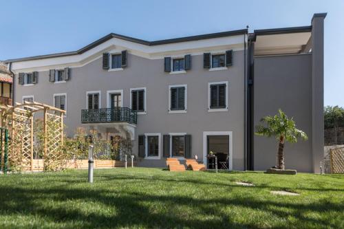 a large white house with a green yard at Residence La Torre con private park in Trieste
