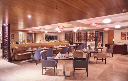 a restaurant with tables and chairs and a bar at The P L Palace Agra in Agra