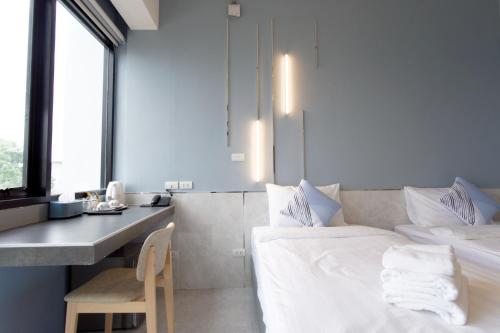 a bedroom with a bed and a desk with a chair at ABIZZ Hotel KwanPhayao in Phayao