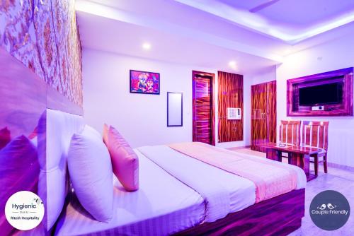a bedroom with a bed and a table and a television at Hotel Fabulous - Delhi International Airport in New Delhi