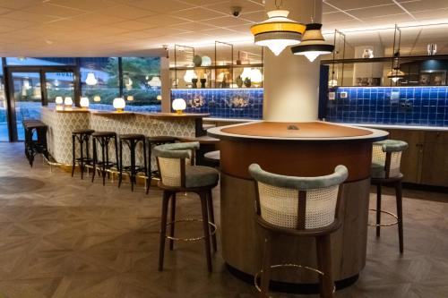 a bar in a restaurant with stools at Novotel Suites Nice Airport in Nice