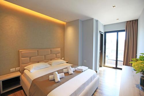 a bedroom with a large bed and a large window at Hotel Citrus in Ksamil