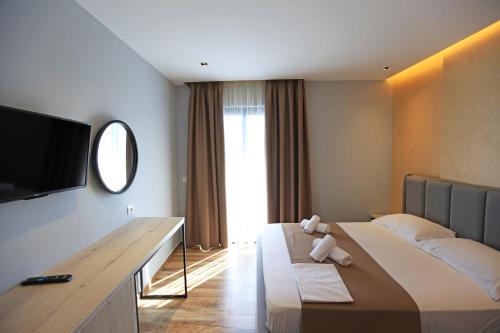 a hotel room with a large bed and a flat screen tv at Hotel Citrus in Ksamil