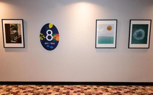 a wall with four framed pictures on a wall at Novotel Suites Nice Airport in Nice