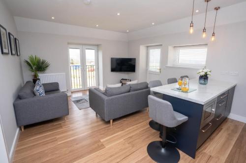 a kitchen and living room with a table and chairs at Stable Court Apartments in Antrim