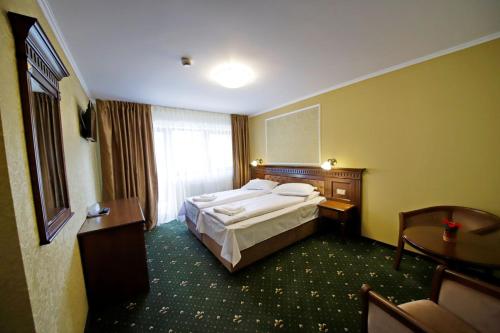 a hotel room with a bed and a window at Montebello in Predeal