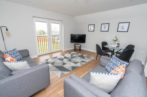 a living room with two couches and a table at Stable Court Apartments in Antrim