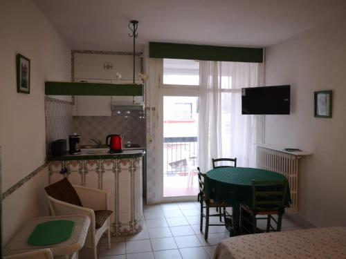 a room with a table and a kitchen with a window at Les Thermes de Vernet-les-bains in Vernet-les-Bains