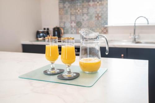 two glasses of orange juice on a tray on a kitchen counter at Stable Court Apartments in Antrim