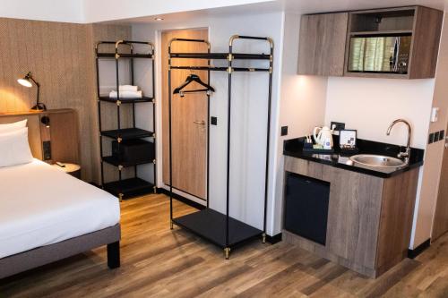 a hotel room with a bed and a sink at Novotel Suites Nice Airport in Nice