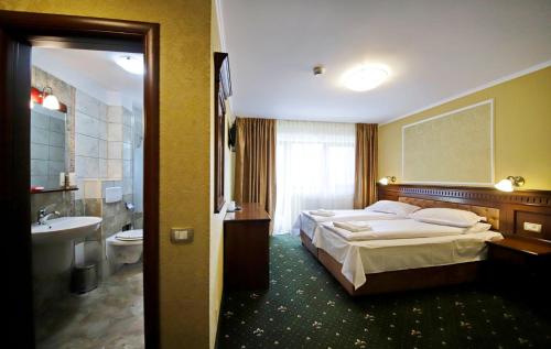 ein Hotelzimmer mit einem Bett und einem Bad in der Unterkunft Montebello in Predeal