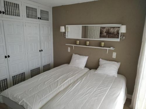 - une chambre avec un lit doté de draps blancs et de placards blancs dans l'établissement Miami APARTAMENTO LAURENT, à Miami Platja