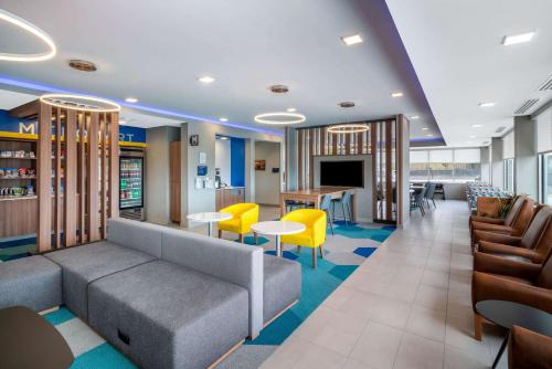 a waiting room with a couch and tables and chairs at Microtel Inn & Suites by Wyndham Hot Springs in Hot Springs