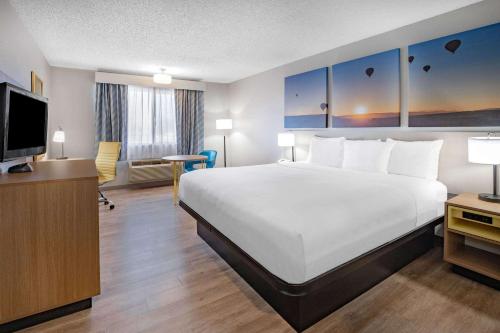 a hotel room with a large bed and a television at Days Inn by Wyndham Bernalillo in Bernalillo
