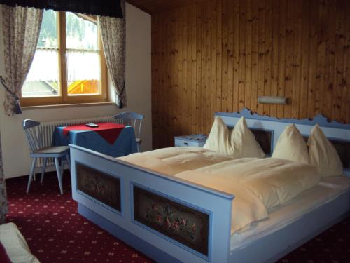 ein Schlafzimmer mit einem großen Bett mit blauem Rahmen in der Unterkunft Neumaierhof in Haus im Ennstal