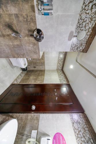 a small bathroom with a toilet and a sink at Regenta Inn Vadodara, 500m from Railway Station in Vadodara