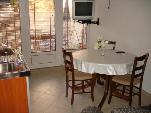 a kitchen with a table with chairs and a tv at Apartments Medin Danilo in Petrovac na Moru