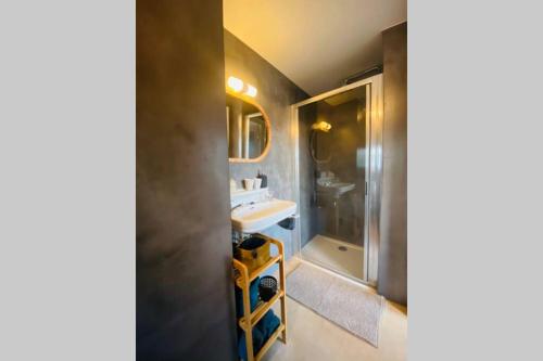 La salle de bains est pourvue d'un lavabo et d'une douche. dans l'établissement Recently renovated appartement 150m from the beach, au Coq