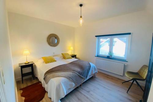 - une chambre avec un lit, une fenêtre et une chaise dans l'établissement Recently renovated appartement 150m from the beach, au Coq