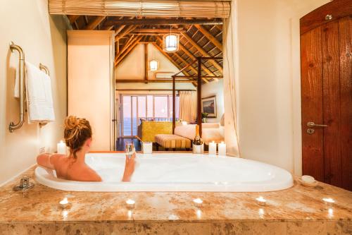 聖弗朗西斯灣的住宿－聖弗朗西斯金沙酒店，坐在一个房间里浴缸里的女人