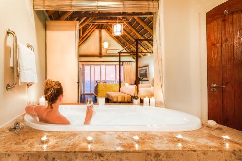 una mujer sentada en una bañera en una habitación en The Sands @ St Francis, en St Francis Bay