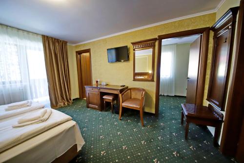 a hotel room with two beds and a desk and a mirror at Montebello in Predeal