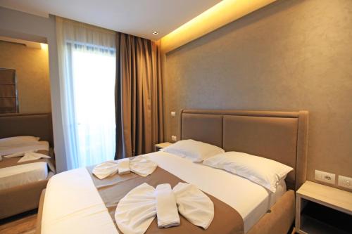 a hotel room with a bed with two towels on it at Hotel Citrus in Ksamil