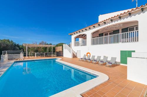 a swimming pool in front of a house at Villa Jasmin in Sant Lluis