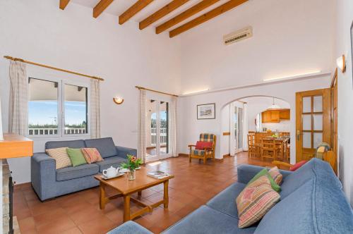 uma sala de estar com um sofá azul e uma mesa em Villa Jasmin em Sant Lluis