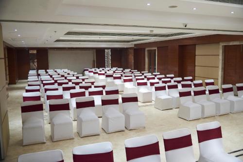 an empty room with white chairs in a room at The P L Palace Agra in Agra