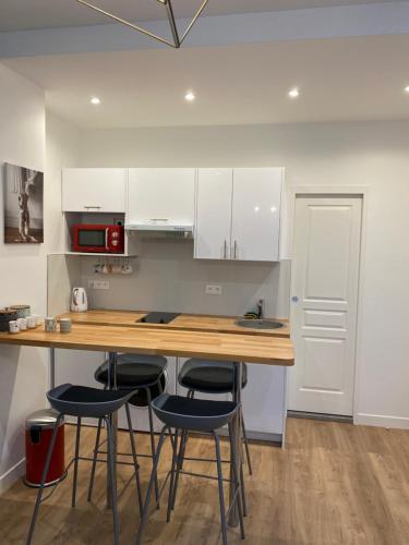 - une cuisine avec un comptoir en bois et des tabourets dans l'établissement Alex's house, à Paris