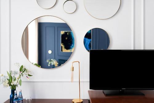 a television in a living room with two mirrors at IBB Hotel Grand Hotel Lublin in Lublin