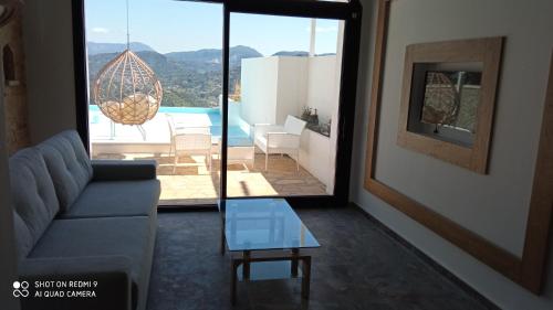 a living room with a couch and a glass table at Zeus Throne Suites in Afionas