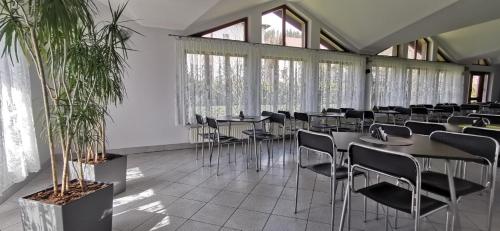 a dining room with tables and chairs and windows at Dom Wczasowy Irys in Węgierska Górka