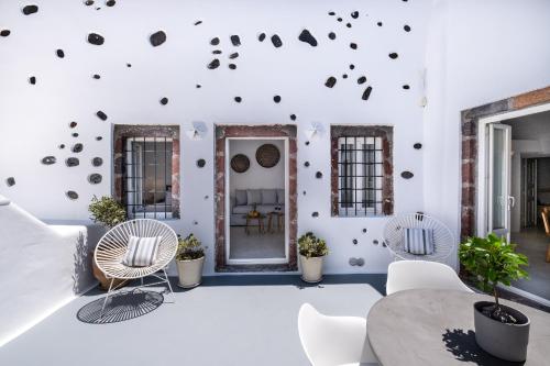 a room with chairs and a table and a wall covered in stickers at Radiant Santorini in Mesaria