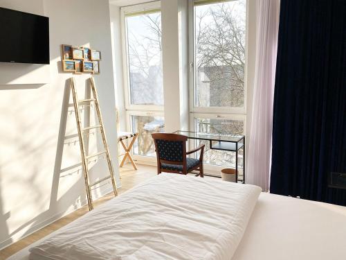 a bedroom with a bed and a ladder and a desk at Kangarooms - Schlachte Weserpromenade in Bremen