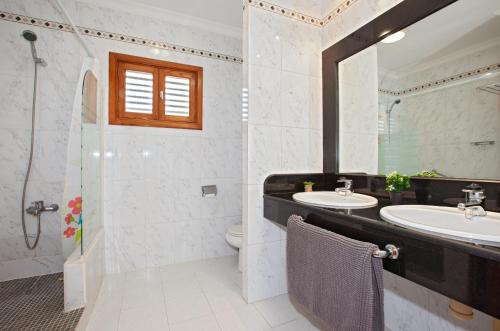łazienka z umywalką, toaletą i lustrem w obiekcie Apartment Caleton Blanco, central Puerto del Carmen w Puerto del Carmen