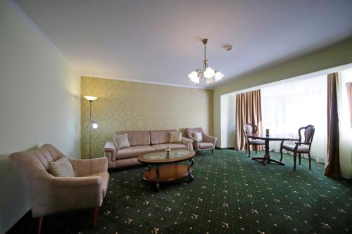 a hotel room with a couch and a table and chairs at Montebello in Predeal