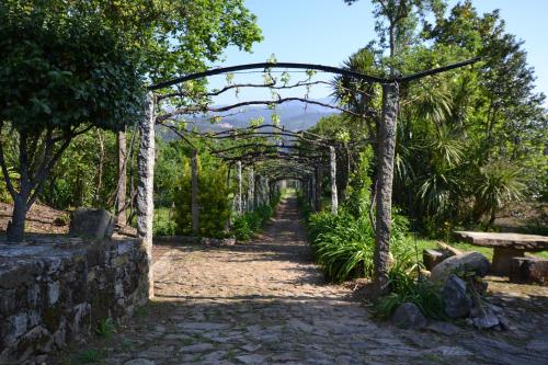 une arche au-dessus d'un chemin dans un jardin dans l'établissement Quinta Da Aldeia, à Ponte de Lima