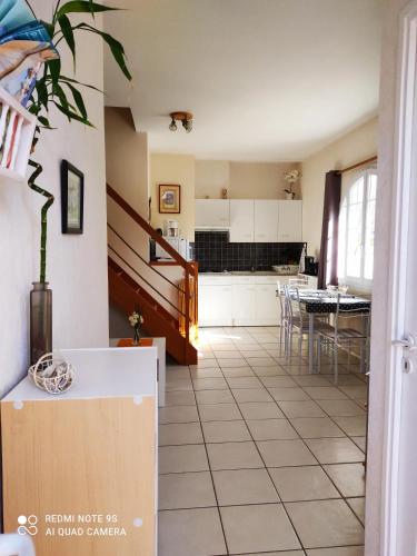 Il comprend une cuisine et une salle à manger avec une table. dans l'établissement GITE JARDIN/TERRASSE COSY PRES PLAGES, à Arès