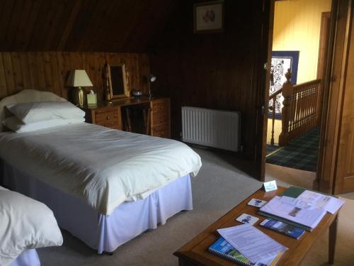 a bedroom with a bed and a table with a table sidx sidx at Westward Bed and Breakfast in Cannich