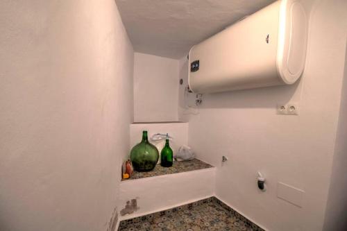 two green bottles sitting on a shelf in a bathroom at Casa Beaumont - awesome Andalusian townhouse in Cómpeta
